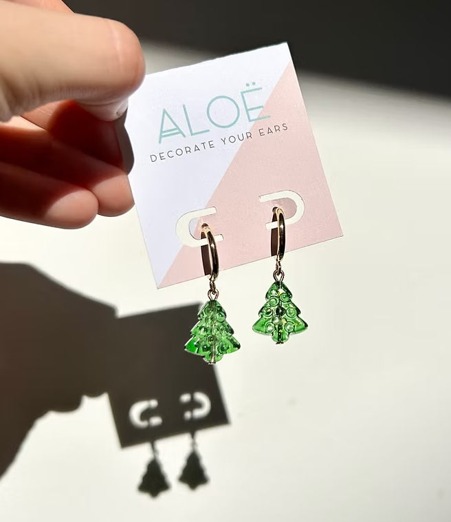 Green earrings on a 'Decorate Your Ears' card held by a hand.