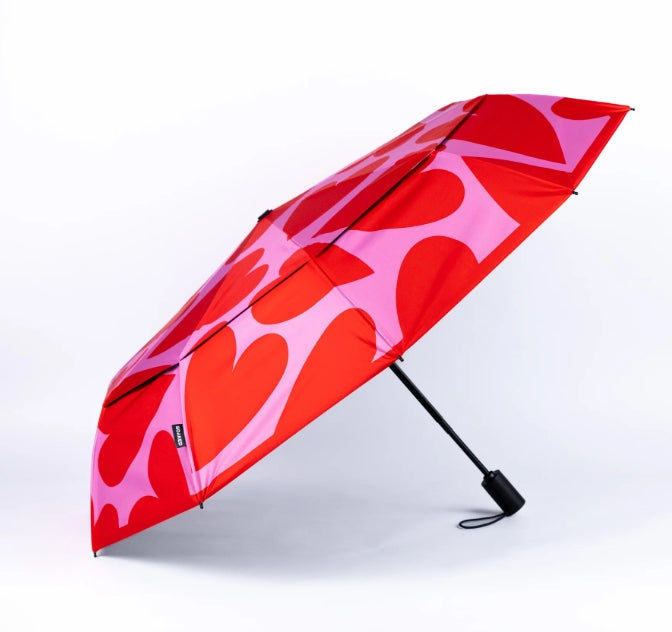 Red and pink heart-patterned umbrella on a white background